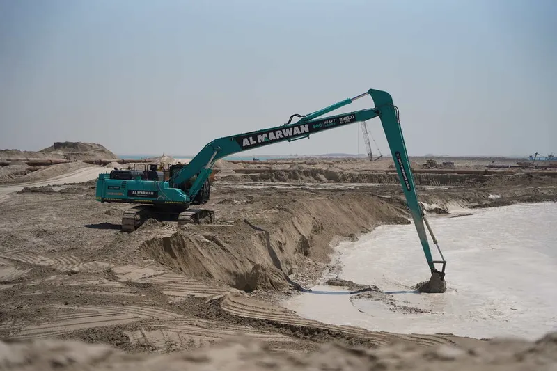 A Kobelco SK500 excavator equipped with a long boom, part of the Al Marwan machinery fleet