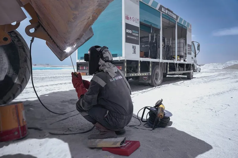 An Al Marwan technician working in the shade with proper PPE