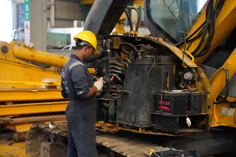Al Marwan technician working on repairing the excavator 