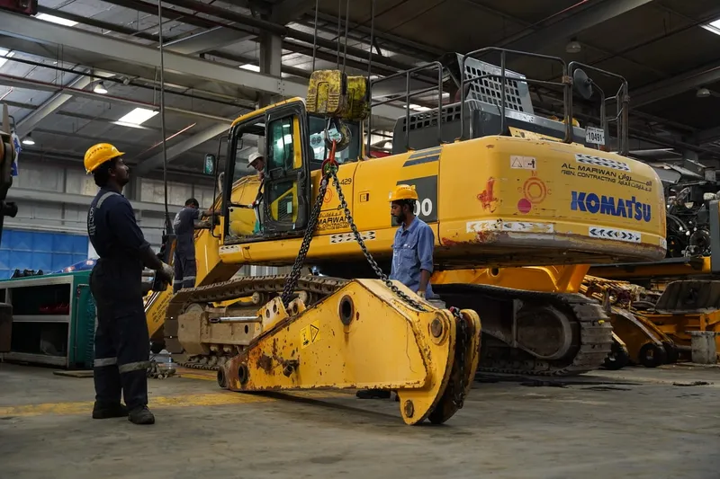 Al Marwan Heavy Machinery's technicians inspect the hydraulic system of an excavator