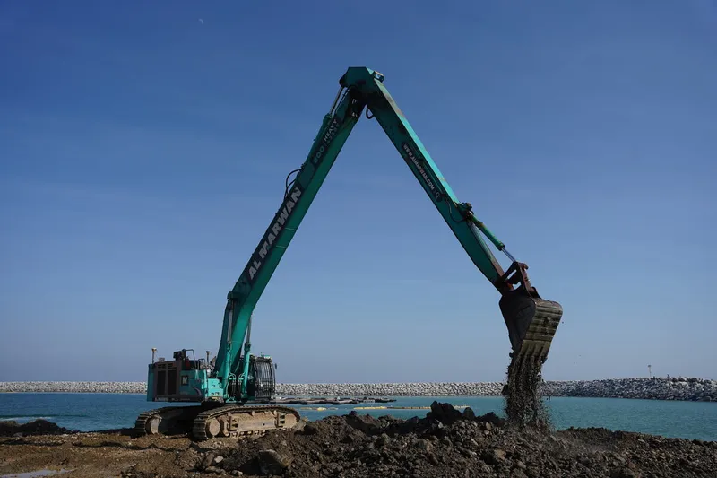 An SK500 Kobelco excavator on a job site as part of Al Marwan Machinery rental fleet