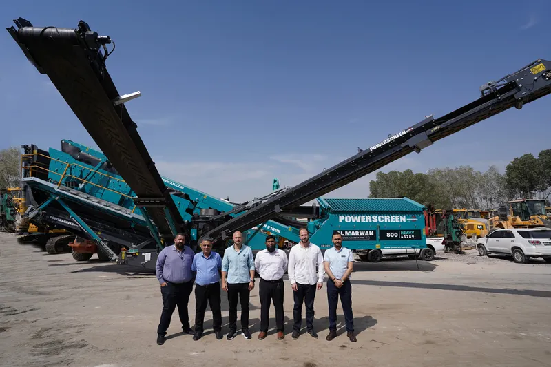 A picture documenting the visit of Powerscreen's regional sales office manager to Al Marwan's HQ standing in front of the Chieftain 2100X screener