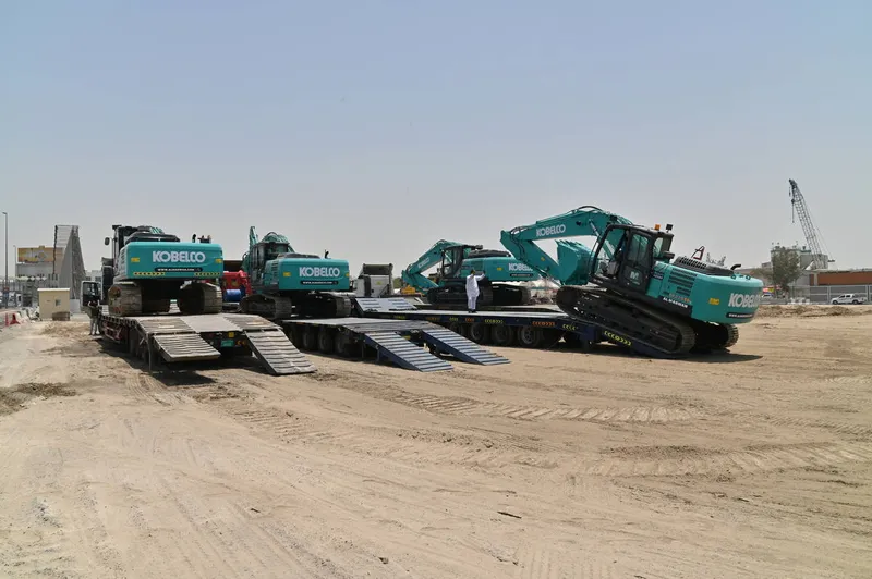 A number of medium KOBELCO SK220 track excavators being loaded off to Oman