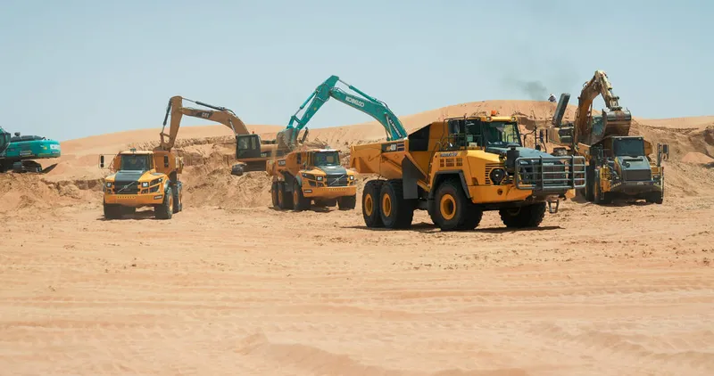Multiple 40 to 45 ton trucks, like the Volvo A45G and the Komatsu HM400, on Al Marwan job site