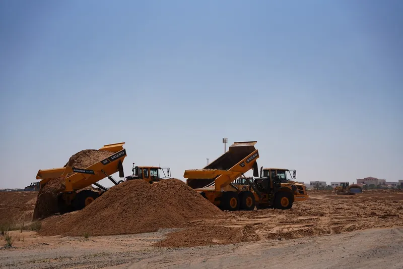 A couple of Volvo A40G's on a construction site in the desert