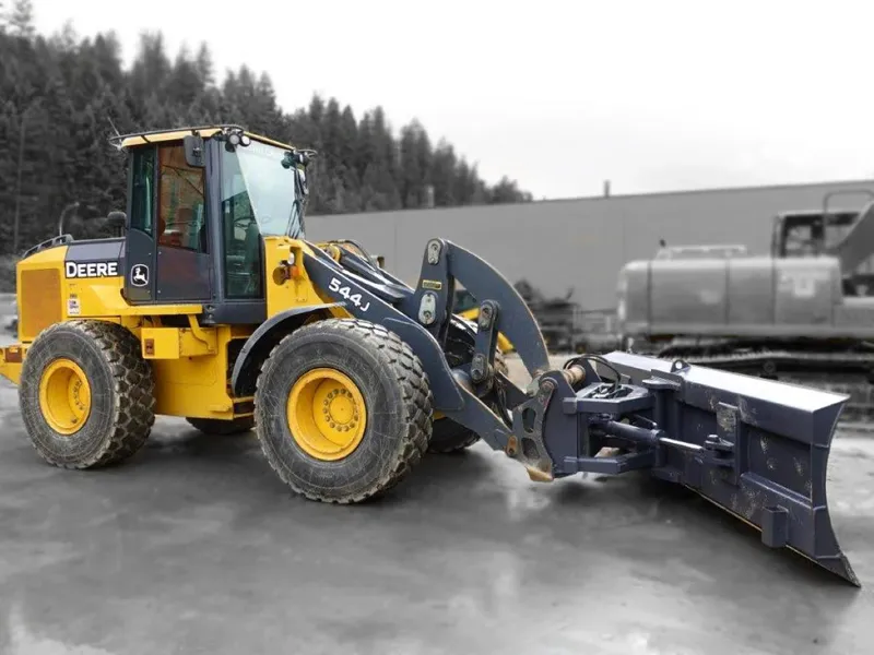 Wheel loader with a blade to push snow