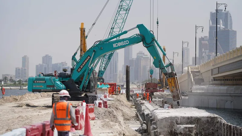 A Kobelco SK380 excavator equipped with a jackhammer for specialized tasks, working with a Komatsu PC450 digger, and a Kobelco CKS1350 crawler crane, on Al Layyah Canal project site