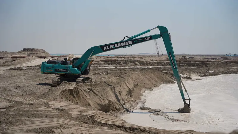 A Kobelco SK500 excavator equipped with a long boom, part of the Al Marwan machinery fleet