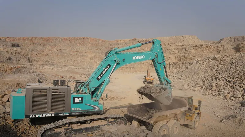 A Kobelco SK850 large excavator loading up a dump truck on Al Marwan job site