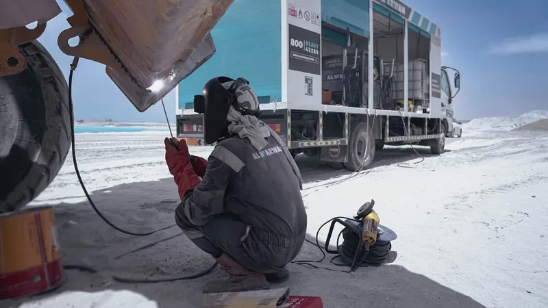 An Al Marwan technician working in the shade with proper PPE