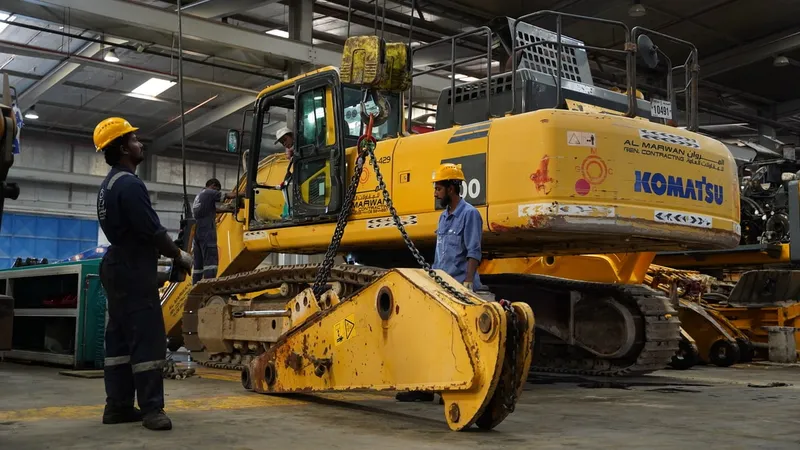Al Marwan Heavy Machinery's technicians inspect the hydraulic system of an excavator