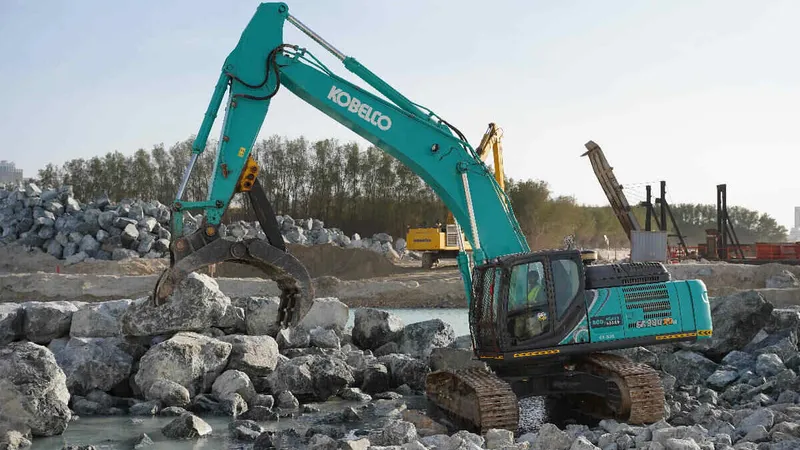 An SK380 medium excavator equipped with a grab attachment