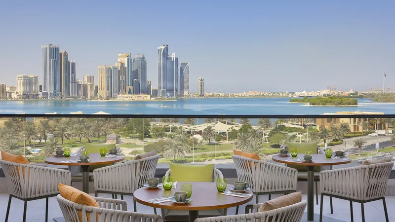 A picture showcasing the panoramic outdoor view of Al Majaz Waterfront and Khalid Lagoon offered by the cozy atmosphere of Majdolin restaurant in the DoubleTree by Hilton Hotel Sharjah