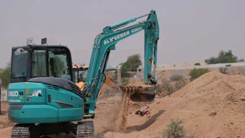 حفارة كوبلكو الصغيرة SK55 أثناء عمليات الحفر في موقع بناء في صحراء الشارقة، الإمارات.