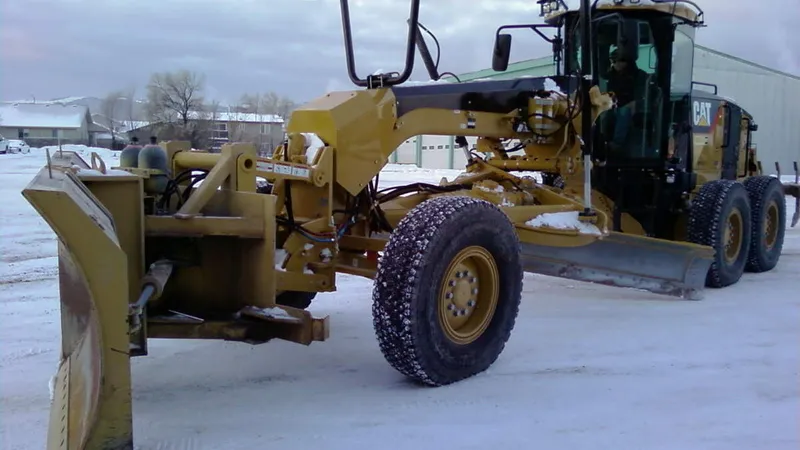 Motor grader attached to a front snow plow