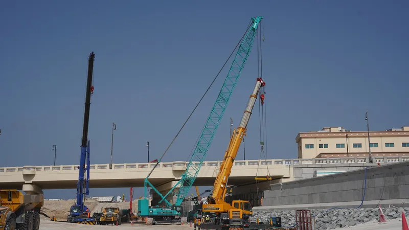 Multiple cranes, including a Kobelco CKS725 crawler crane on Al Layyah Calanal job site