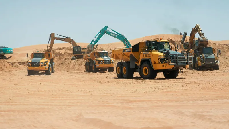 Multiple 40 to 45 ton trucks, like the Volvo A45G and the Komatsu HM400, on Al Marwan job site