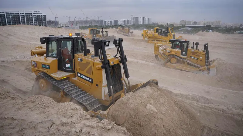 Multiple Al Marwan rental dozers on a job site, including CAT D8T, CAT D9R, Komatsu D475A
