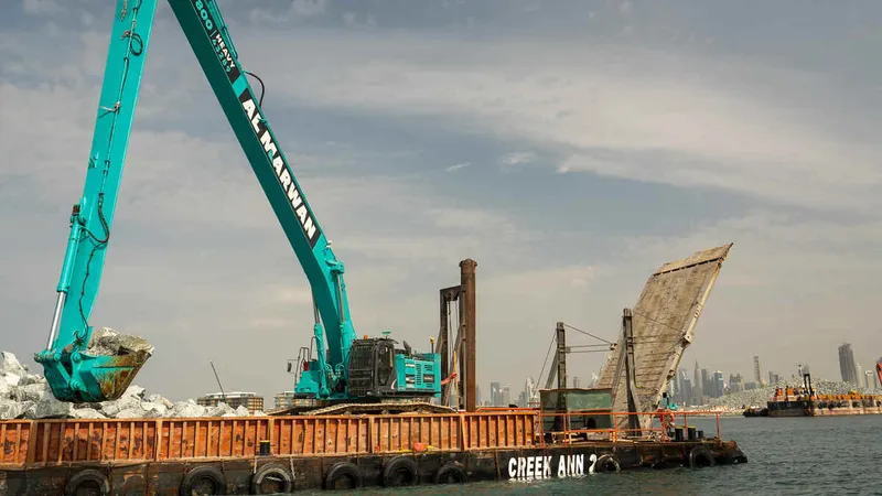Kobelco SK850 long boom excavator in action for a marine project.