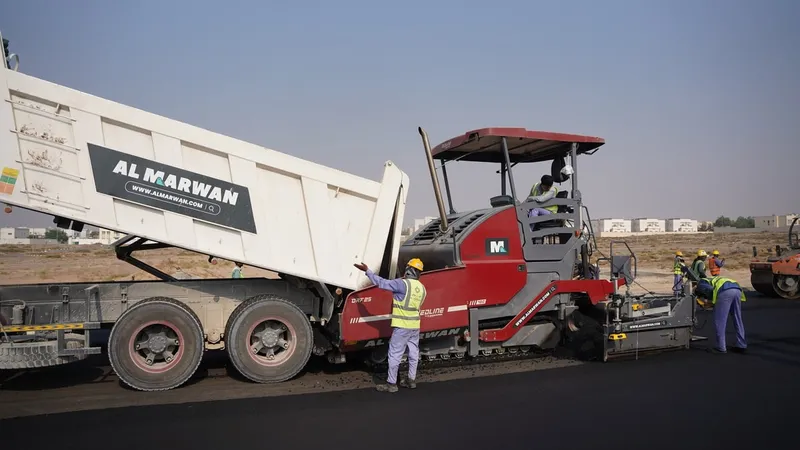 قلاب فولفو أثناء نقله الأسفلت الجديد إلى آلة رصف الأسفلت من دينباك.