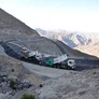The rental fleet of Al Marwan, notably Volvo and Hino tipper trucks dropping asphalt onto Vogele asphalt-laying pavers on Jebel Jais Road