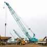 A Kobelco CKS1350 crawler crane lifting a CAT 773E dump truck into place