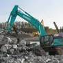 An SK380 medium excavator equipped with a grab attachment