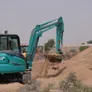 The KOBELCO SK55 mini excavator digging on an Al Marwan Machinery's rental project in the desert in Sharjah, UAE