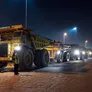 A lineup of Al Marwan's CAT and Komatsu rigid dump trucks being moved out of their Jebel Ali Free Zone (JAFZA) Yard in Dubai to be shipped
