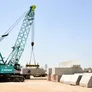 A KOBELCO CKS800 hydraulic crawler crane lifting concrete barriers in Sharjah, UAE