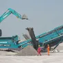 An excavator and a screener on a job site, from Al Marwan, the region's authorized distributor for brand-new Kobelco and Powerscreen equipment