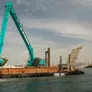 Kobelco SK850 long boom excavator in action for a marine project.
