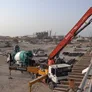 A concrete pump truck laying fresh material into a newly constructed building