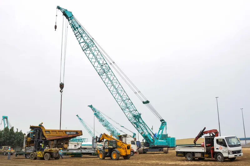A Kobelco CKS1350 crawler crane lifting a CAT 773E dump truck into place