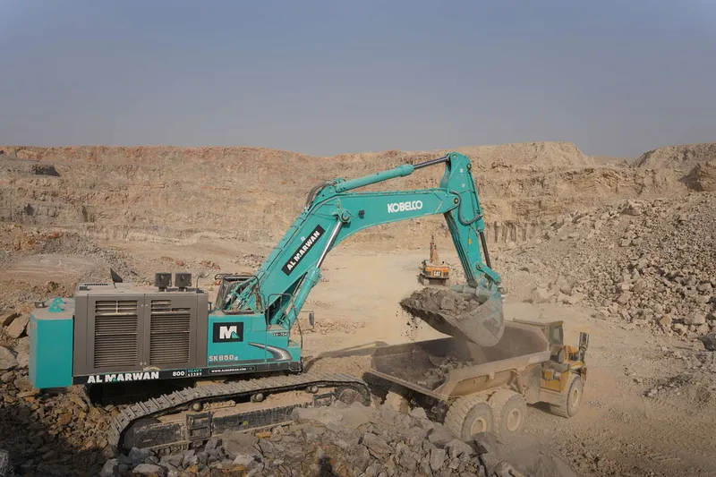 A Kobelco SK850 large excavator loading up a dump truck on Al Marwan job site