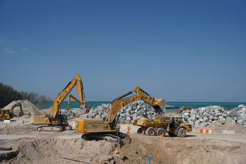 A fleet of rental machinery on Al Marwan worksite including Volvo A40G trucks and CAT 395 excavators