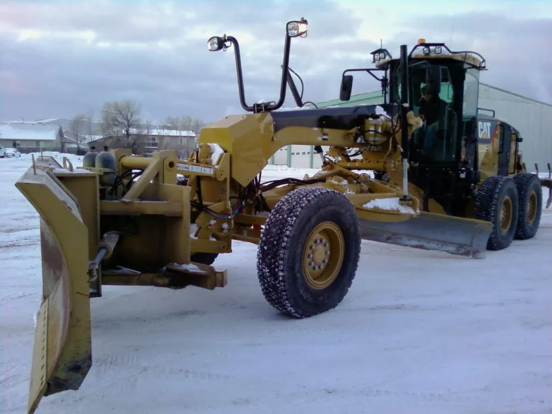 Motor grader attached to a front snow plow