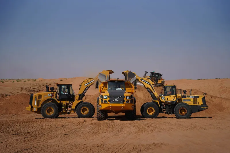 Komatsu WA470 & CAT 966L rented loaders working alongside a Volvo A40G dump truck from Al MArwan's rental fleet