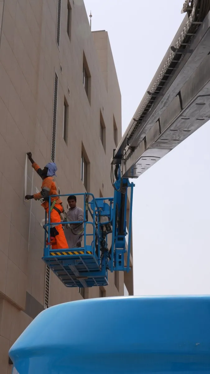 Technicians performing façade maintenance using a Sinoboom boom lift.